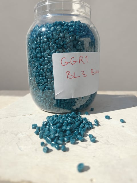 Green Muscat blue polymer granule sample in a labelled jar