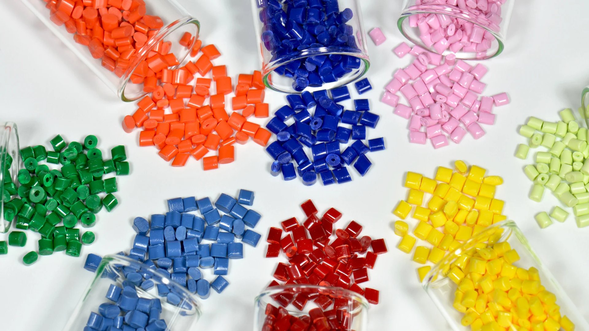 Colourful polymer granules arranged on a white surface